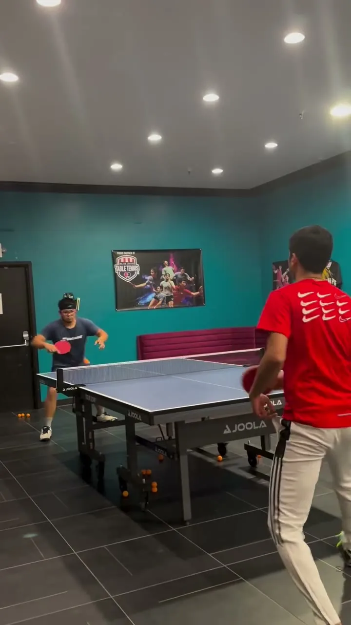 A rally at one of the tables, teal wall behind, on a Thursday night at the club